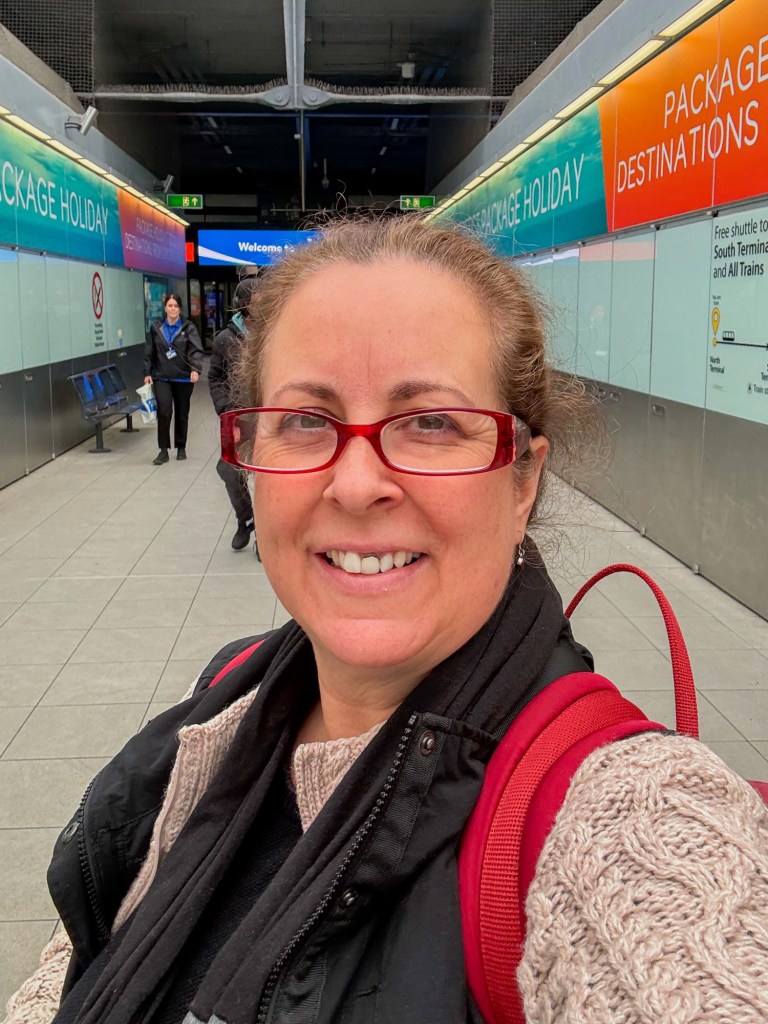 Charlotte (half-asleep) standing in the terminal where the airport transport trains pick up and drop off between terminals.